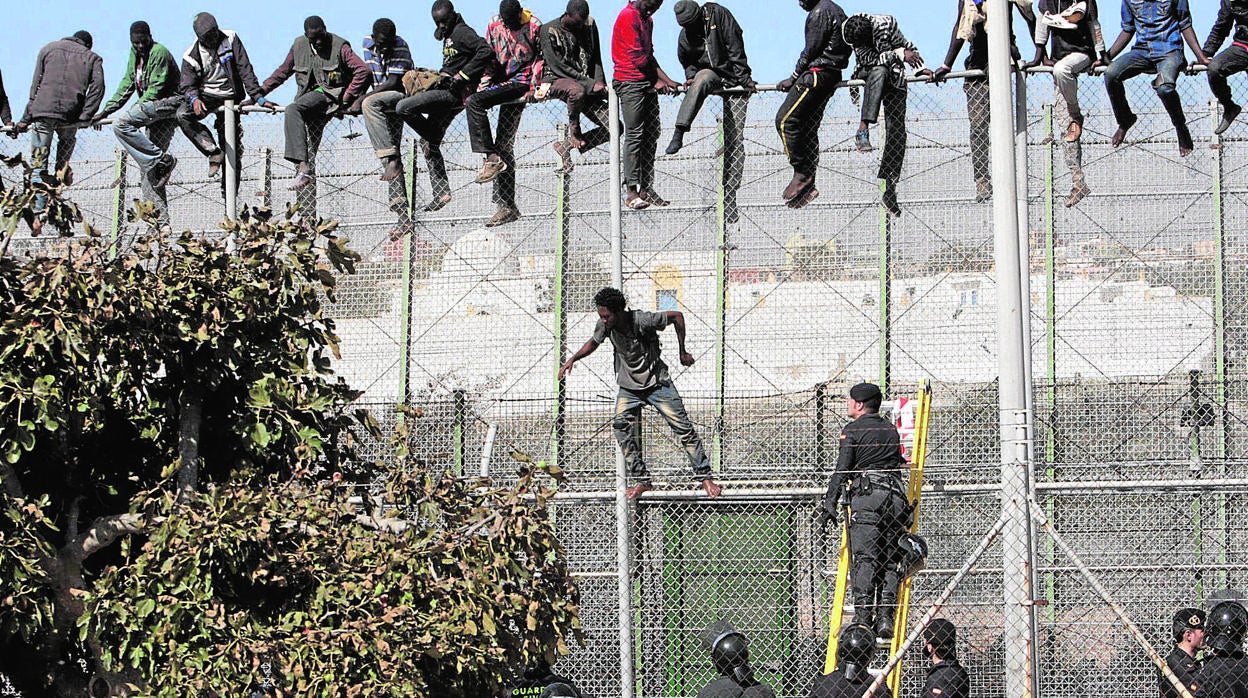 Imagen de recurso de inmigrantes encaramados en la valla de Melilla