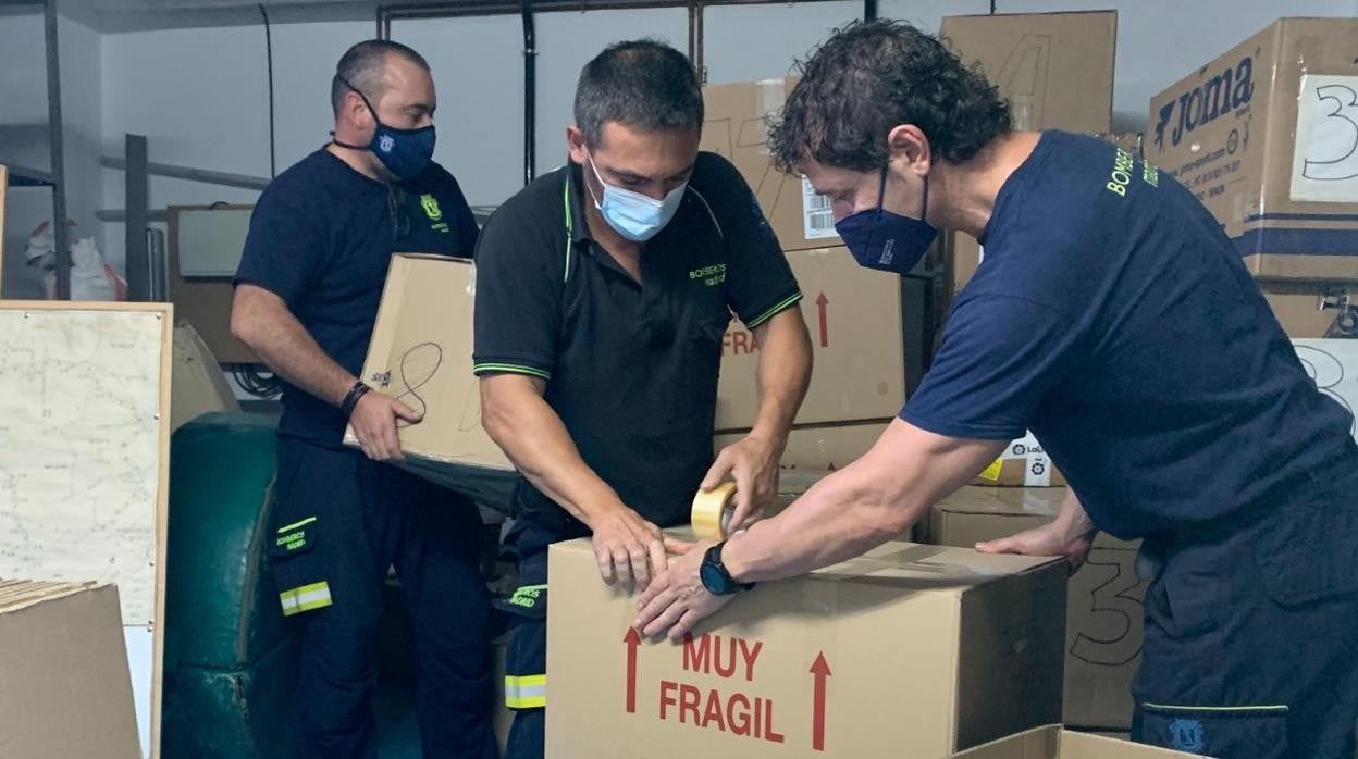 Un grupo de bomberos empaqueta las cajas para el envío del material