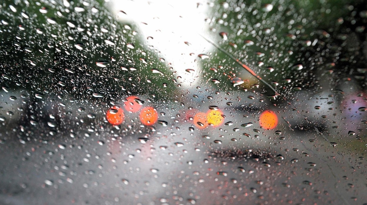 Coches circulan bajo la lluvia