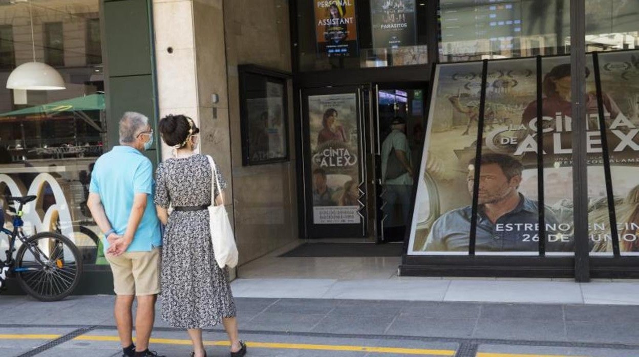 Dos ciudadanos a las puertas de una sala de cine abierta en Madrid durante la pandemia