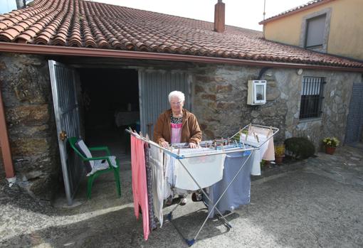 Una vecina de Toques, frente a la entrada de su casa