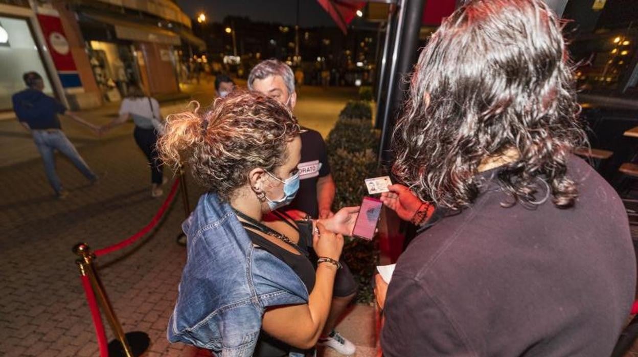 Una mujer mostrando el certificado Covid para acceder a un local en Sanxenxo este verano