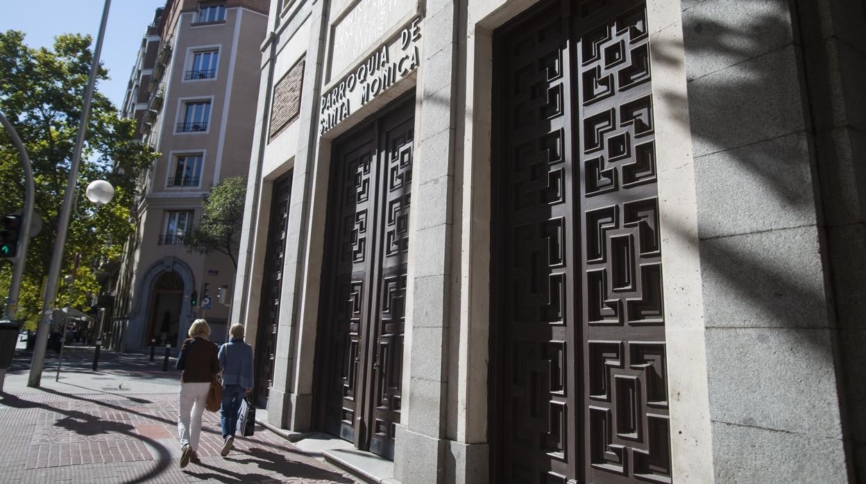 Dos mujeres pasean frente a la puerta de la parroquia de Santa Mónica