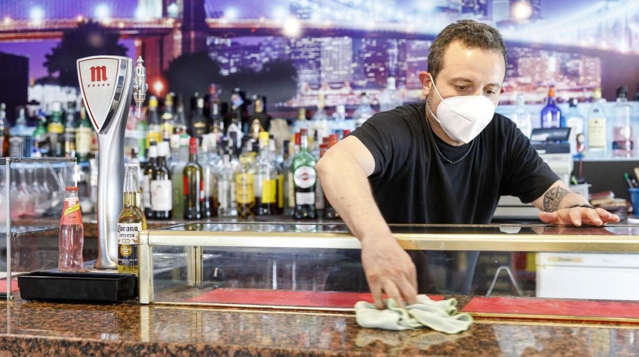 Un camarero limpia la barra de un bar segoviano