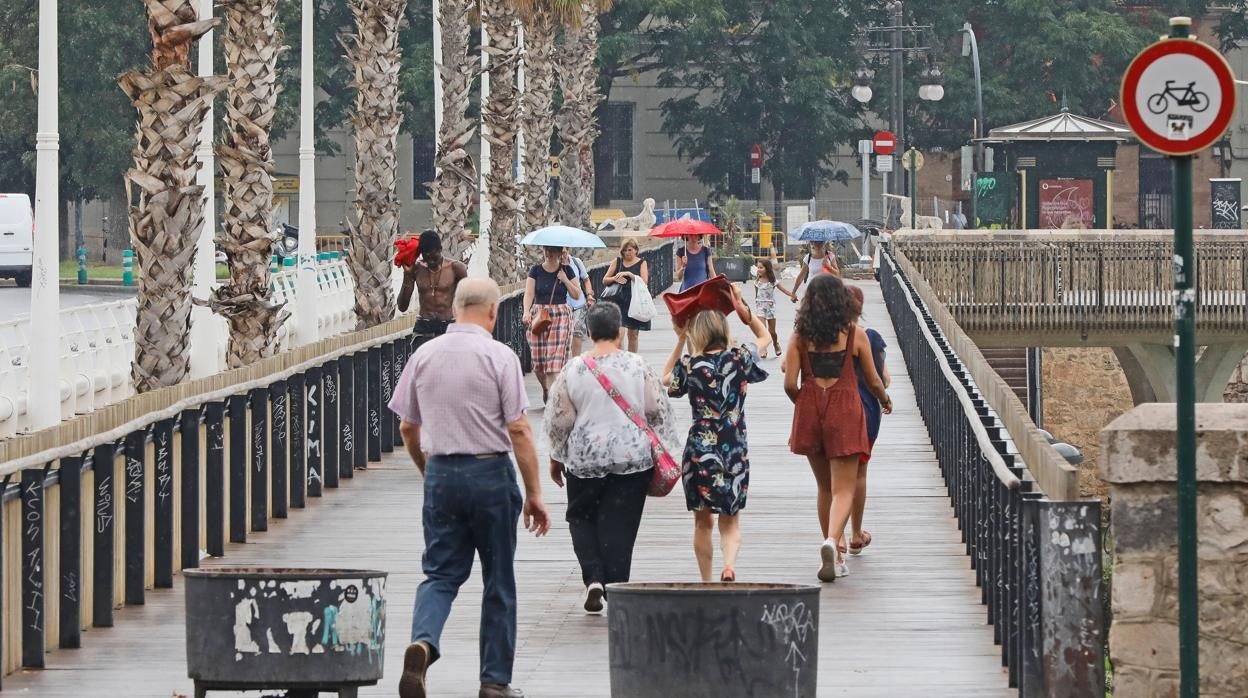 Imagen de archivo de numerosos viandantes caminando por Valencia en un día lluvioso