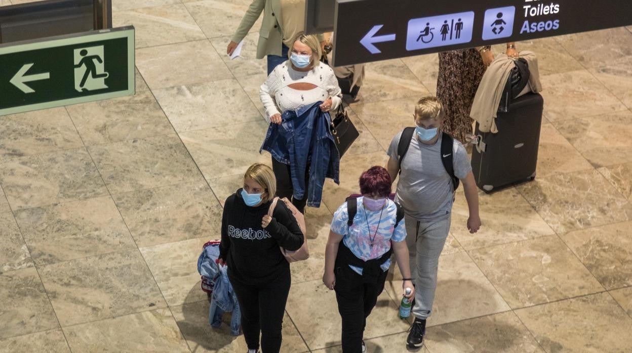 Imagen de archivo de pasajeros con mascarilla en el aeropuerto de Alicante-Elche