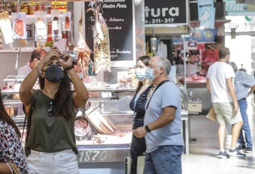 Imagen de varios visitantes en uno de los puestos del Mercado Central de Valencia