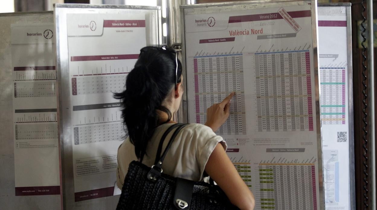 Imagen de archivo de una mujer ante un panel informativo de Renfe en Valencia