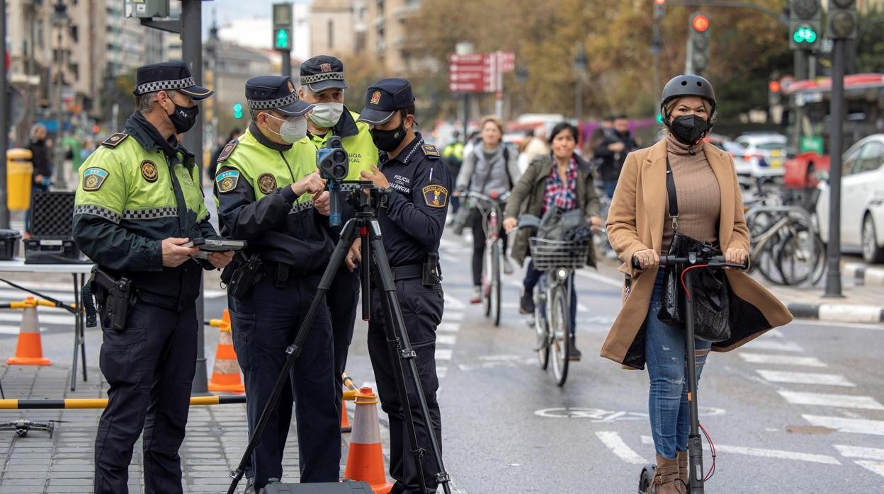 Imagen de una usuaria de patinete eléctrico pasando junto a un radar instalado por la Policía Local en Valencia