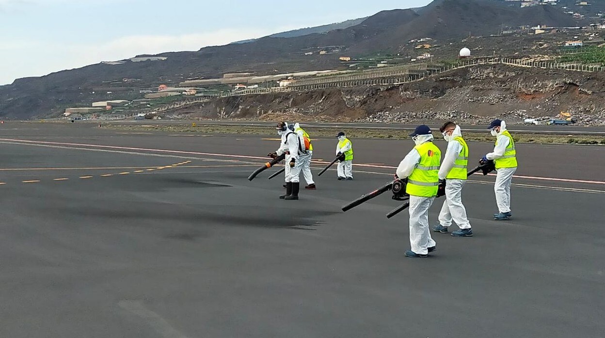 Operarios del aeropuerto limpian pistas de ceniza con sopladores
