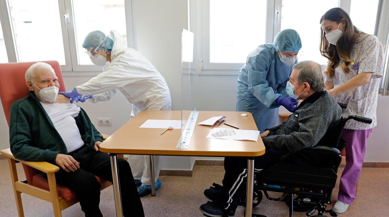 Imagen de archivo de dos personas mayores recibiendo la vacuna contra el coronavirus en Valencia