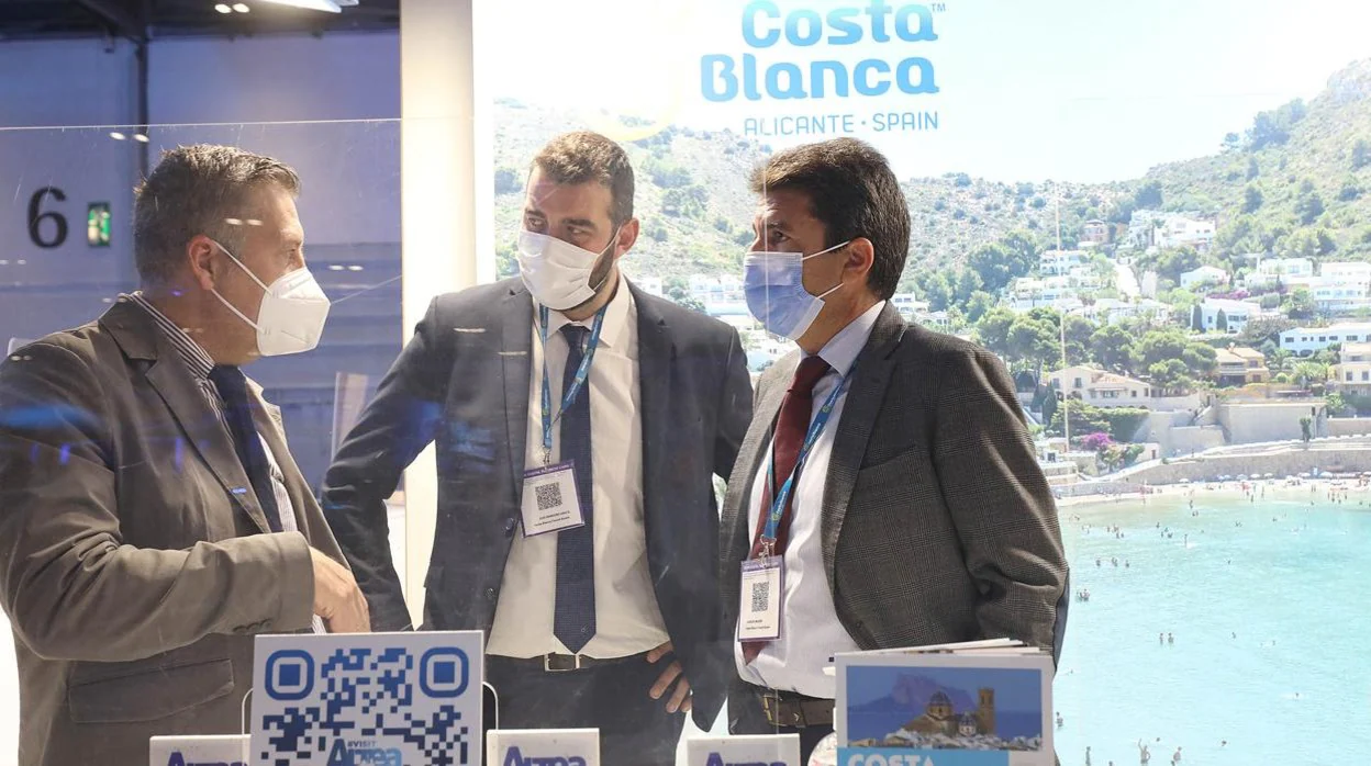 El presidente de la Diputación de Alicante, Carlos Mazón (derecha), y el director del Patronato Costa Blanca, José Mancebo (centro), en el stand del organismo en una feria del turismo