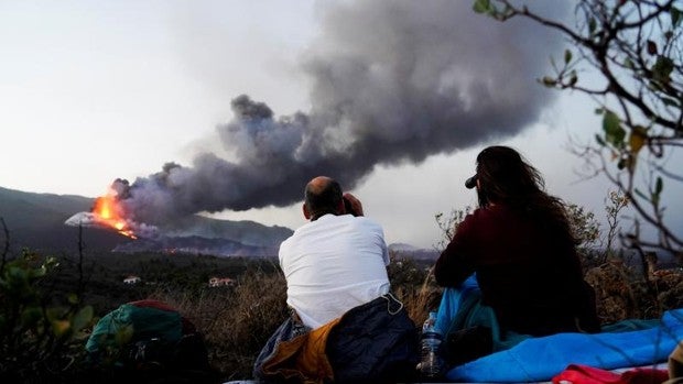 Dos personas observan el cono del volcán de La Palma