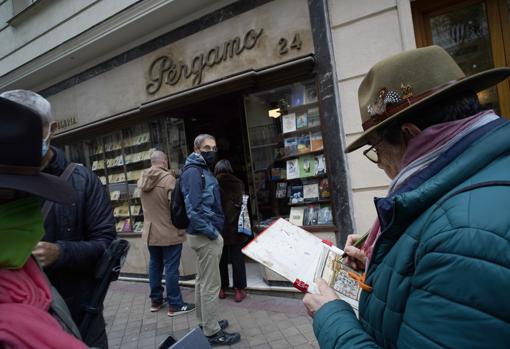 Vecinos del barrio y curiosos hacen cola para entrar a la liquidación de la librería