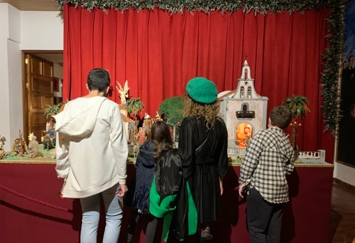 Remedios Armas con sus hijos, ante el Belén de la Iglesia de San MIguel.