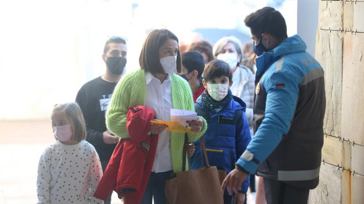 Una madre y unos niños esperando hacen cola para vacunarse en la Cidade da Cultura de Santiago