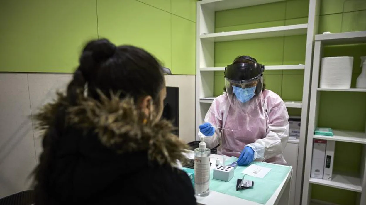Una profesional realiza una prueba de antígenos en una farmacia de Barcelona