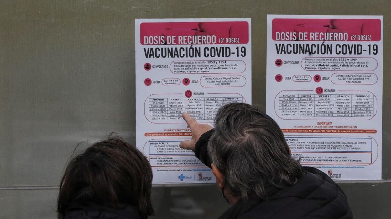 Una pareja revisa los avisos para la tercera dosis de vacunación contra el Covid