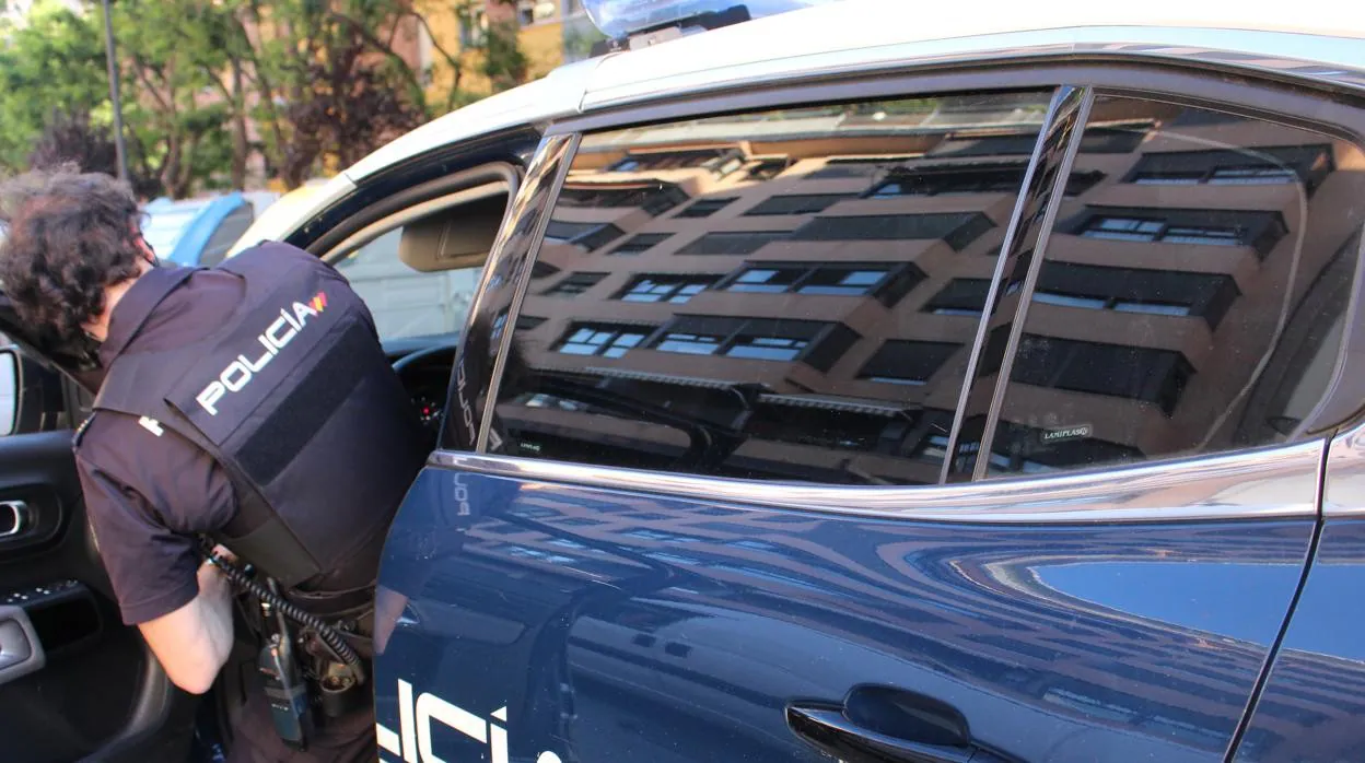 Un agente sube a un coche de la Policía Nacional