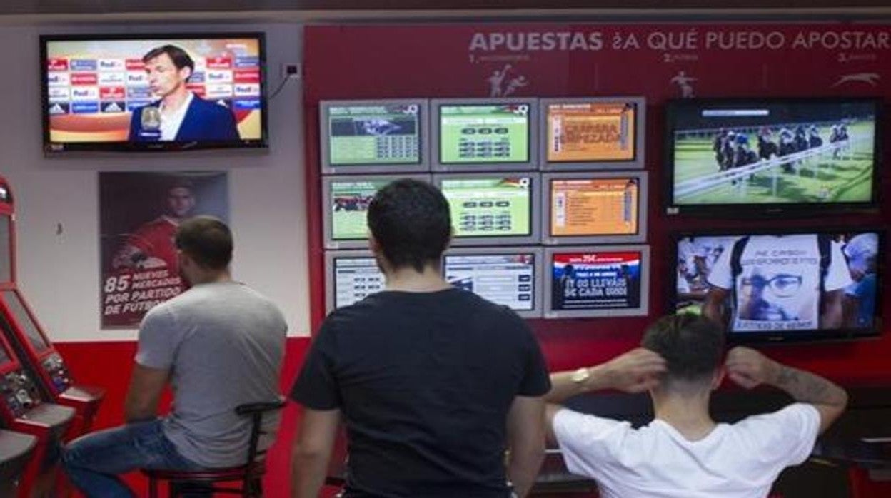 Jóvenes viendo un partido de fútbol en una casa de apuestas