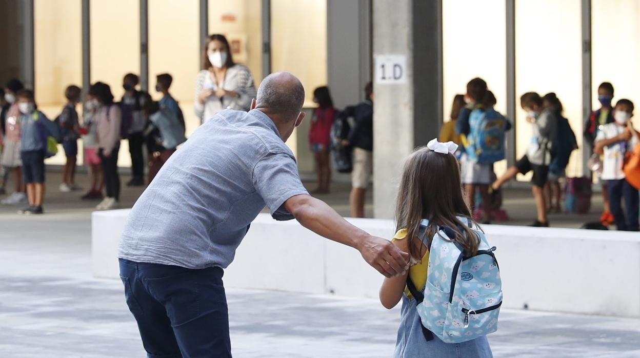 Alumnos con mascarilla en la entrada de un centro de educación primaria