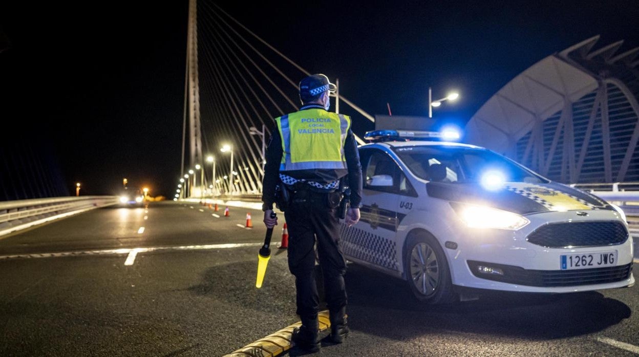 Imagen de archivo de un agente de la Policía Local de Valencia junto a su coche patrulla