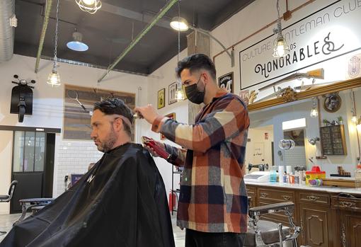 Nando Díaz le corta el pelo a un cliente