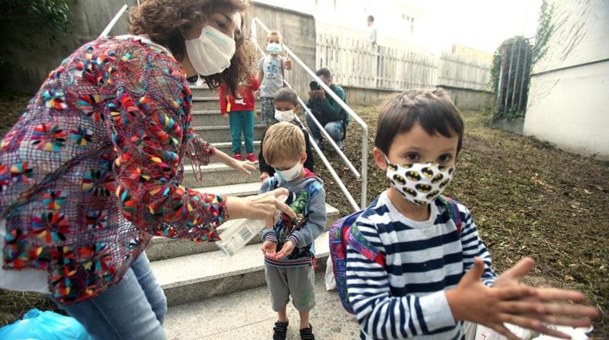 Niños con mascarillas en el exterior de un colegio de Santiago