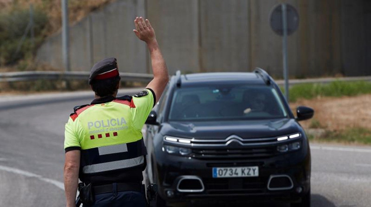 Un agente de los Mossos d'Esquadra parando a un coche, en una imagen de archivo