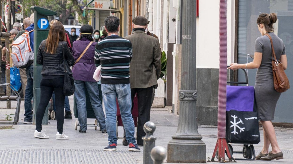 Imagen de archivo de un grupo de personas haciendo cola para entrar en un supermercado en Valencia