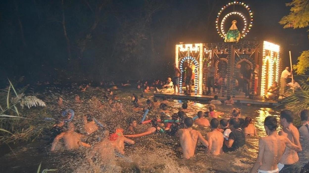 La 'Embarcación' de la Virgen de Alarilla, con su corte de nadadores, bajando por el río Tajo