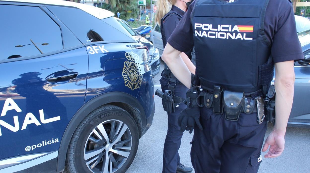 Imagen de recurso de varios agentes de la Policía Nacional junto a su coche patrulla