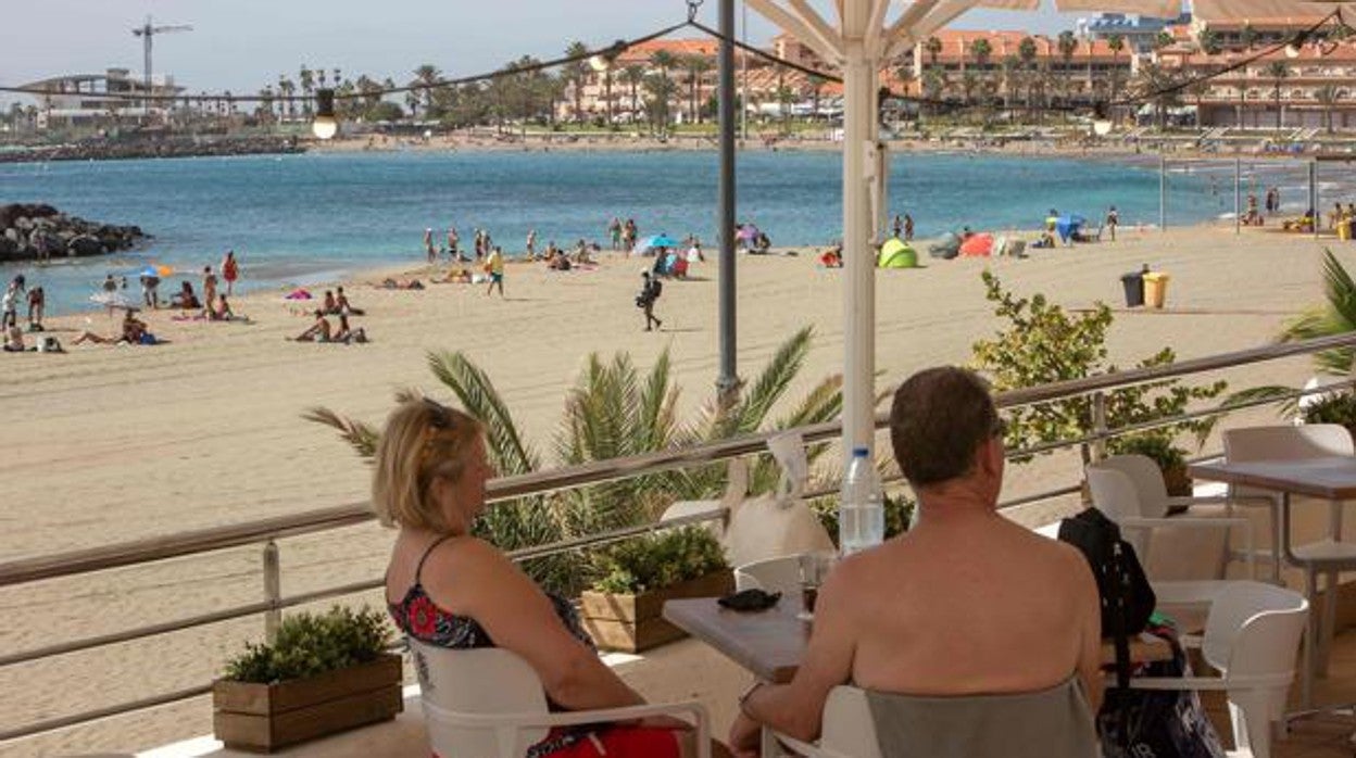 Turistas disfrutan de una terraza a pie de playa en Tenerife