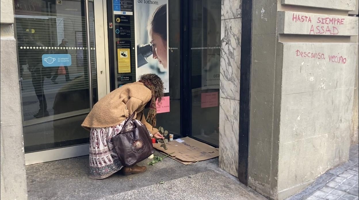 Una mujer deposita una rosa en el cajero donde dormía Assad / E.B.