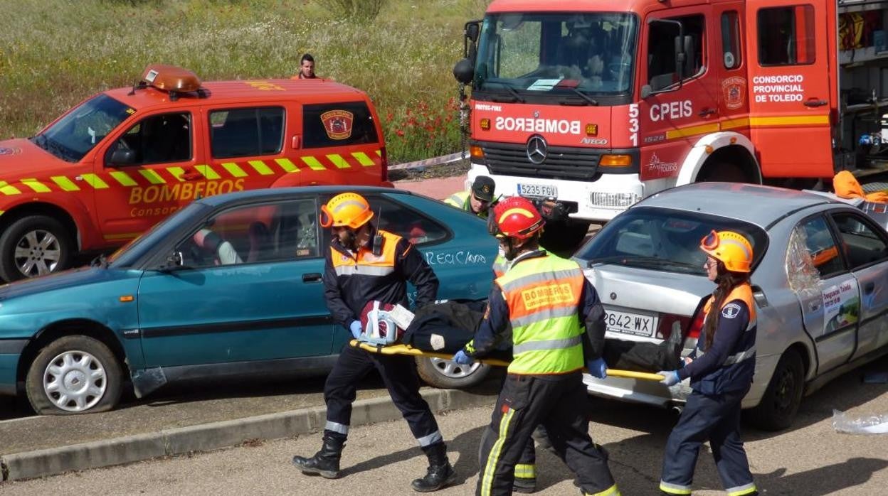 Bomberos y personal sanitario trasladan a un herido en accidente de tráfico