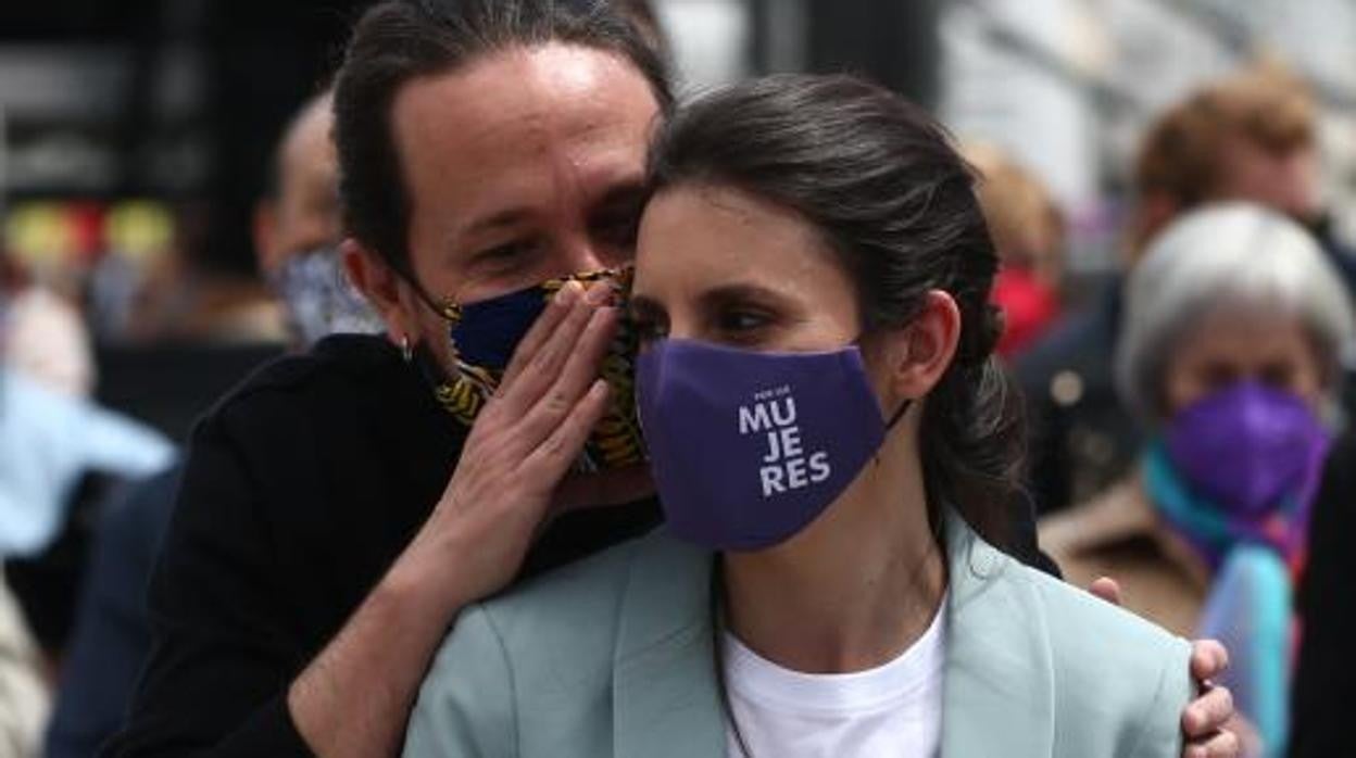 El exlíder de Podemos, Pablo Iglesias, habla al oído a la ministra de Igualdad, Irene Montero, en una concentración del Primero de Mayo del año pasado