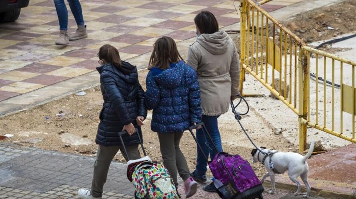 Varios niños se dirigen a clase a las puertas de un colegio