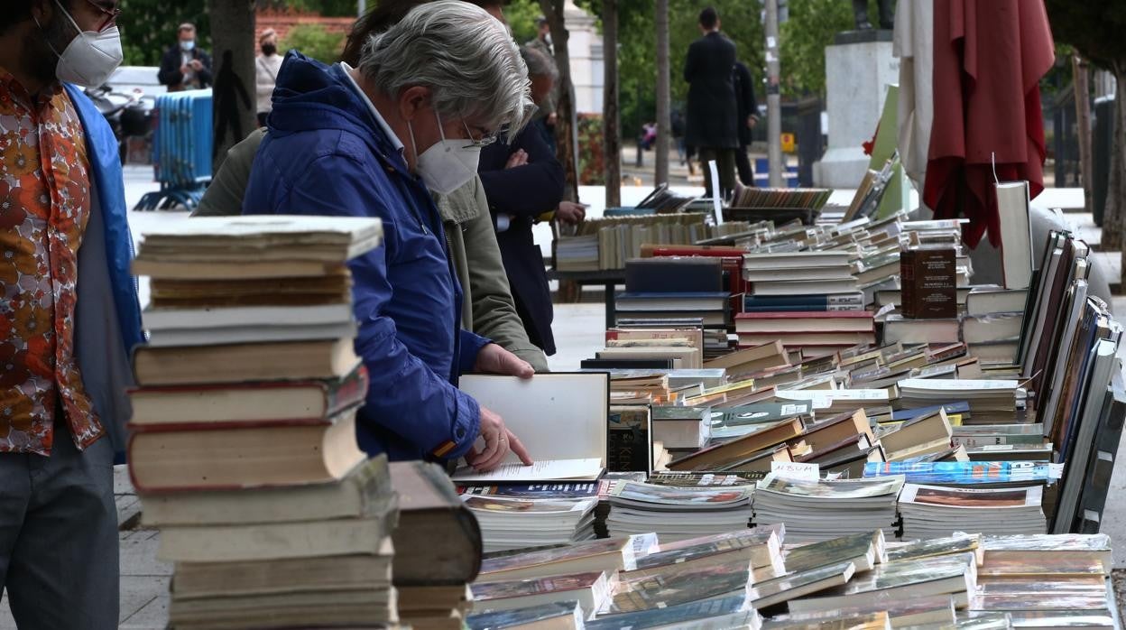 Un lector ojea un libro en un puesto de la Cuesta de Moyano