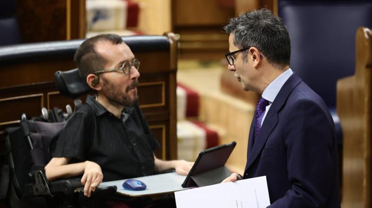 El portavoz de Unidas Podemos en el Congreso, Pablo Echenique (i), y el ministro de la Presidencia, Félix Bolaños, conversan en una sesión plenaria, en el Congreso de los Diputados