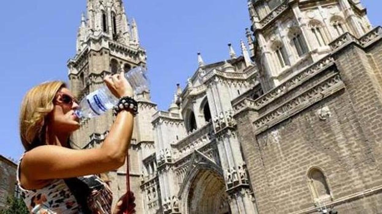 Una turista bebe agua frente a la catedral de Toledo