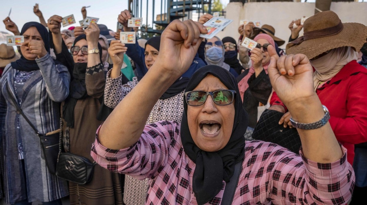 Mujeres protestan con los documentos que les permitián pasar a España en la frontare de Marruecos con Ceuta al no dejarles entrar a territorio español