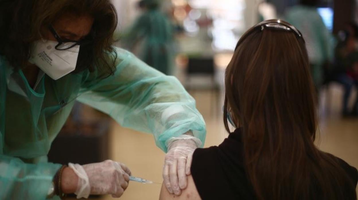 Una sanitaria vacuna frente al Covid a una ciudadana, en Madrid