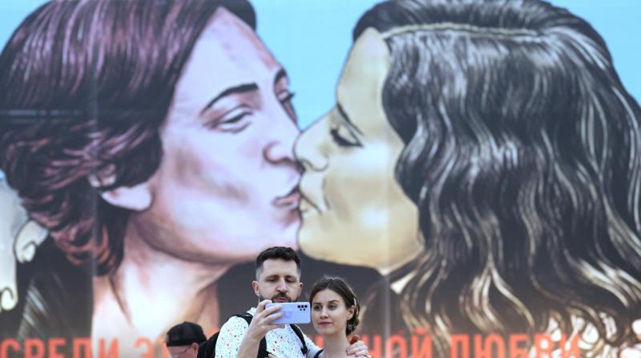 Una pareja se fotografía en el mural de las alcaldesas de Barcelona y Madrid, Ada Colau e Isabel Díaz Ayuso, en el Primavera Sound de Barcelona