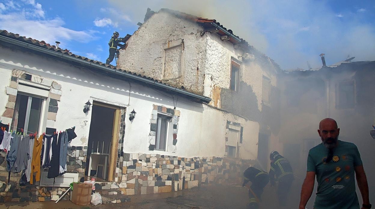 Los bomberos sofocan el fuego en la vivienda incendiada