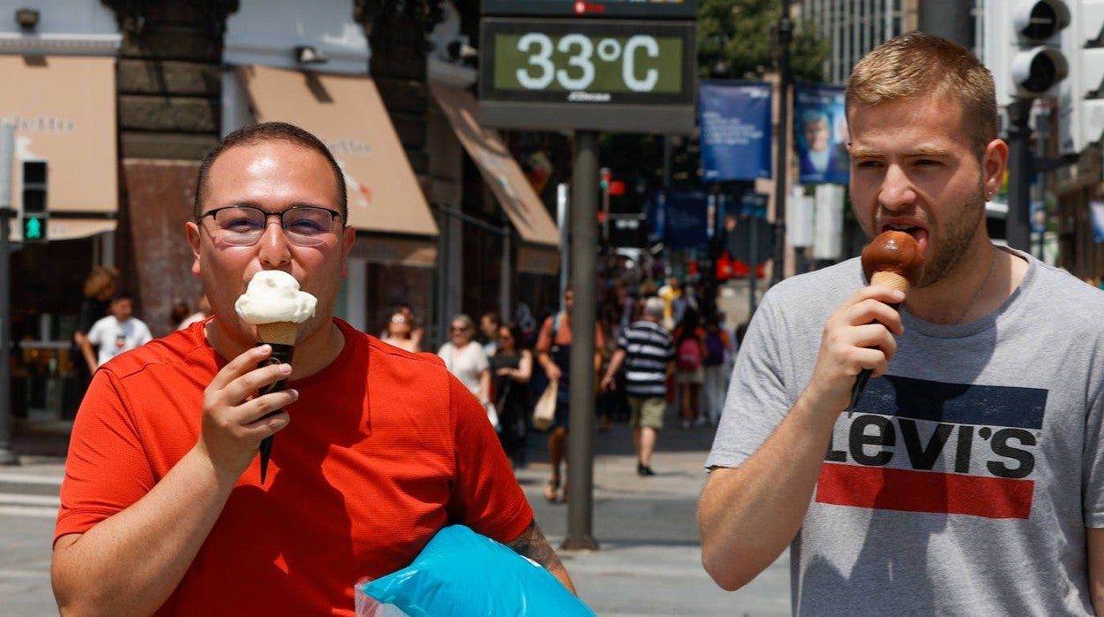 Dos jóvenes se refrescan con un helado en Bilbao