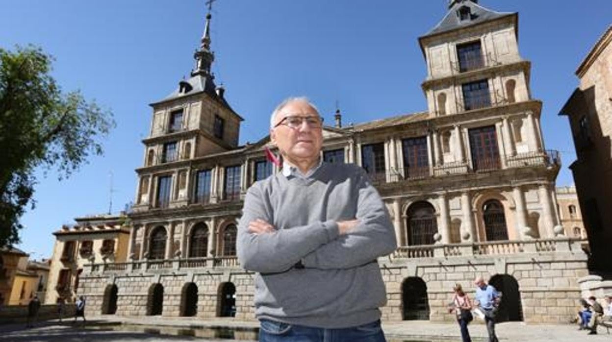 El escritor y periodista Enrique Sánchez Lubián posa con el Ayuntamiento de Toledo a su espalda