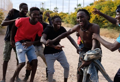 Varios migrantes se dirigen al Centro Temporal de Inmigrantes (CETI), mientras celebran el salto de la valla de Melilla, a 24 de junio de 2022, en Melilla (España)