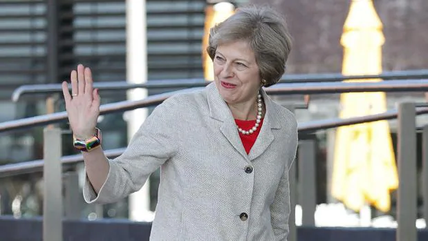 Theresa May combina vestidos clásicos con collares
