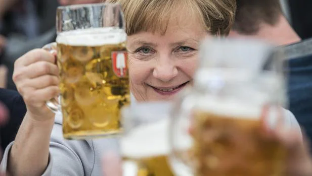 Merkel brinda con una jarra de cerveza durante un evento de la campaña electoral de la Unión Cristianodemócrata