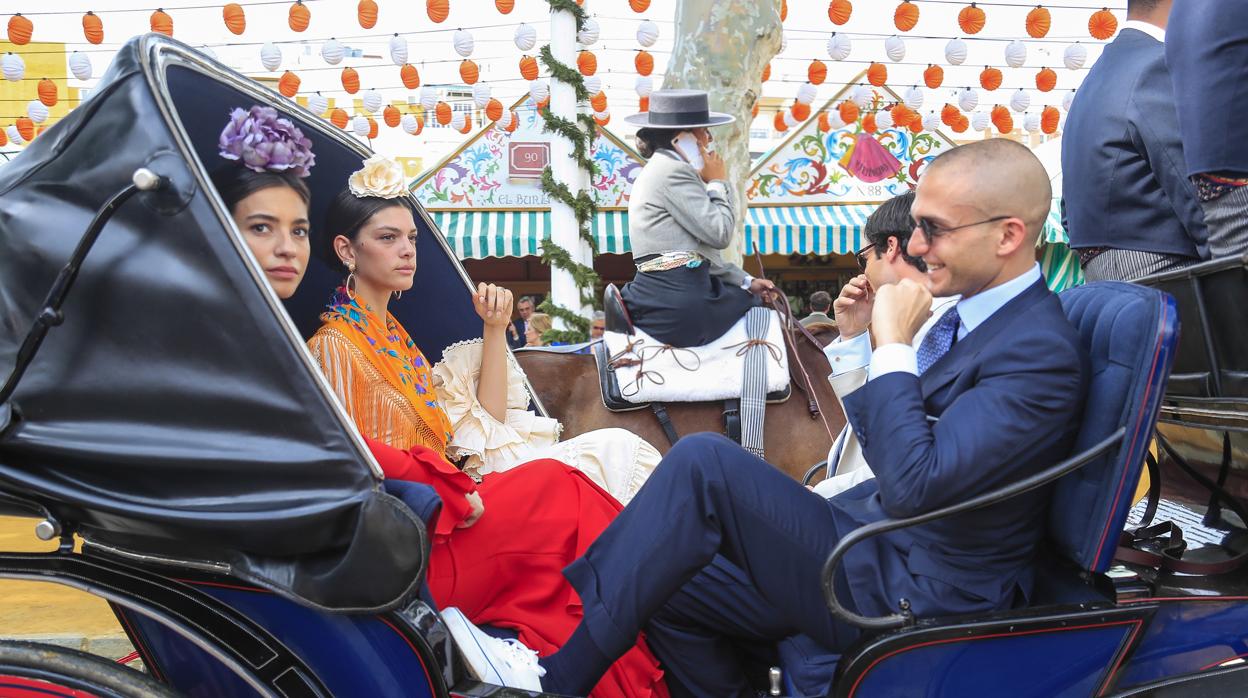 Las modelos Rocío Crusset y Marta Ortiz y el joven Maggio Cipriano pasean en calesa por las casetas de la Feria de Abril de Sevilla